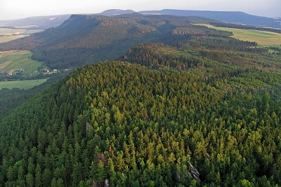 Symetrický hřeben Broumovských stěn se Stolovými horami v pozadí.